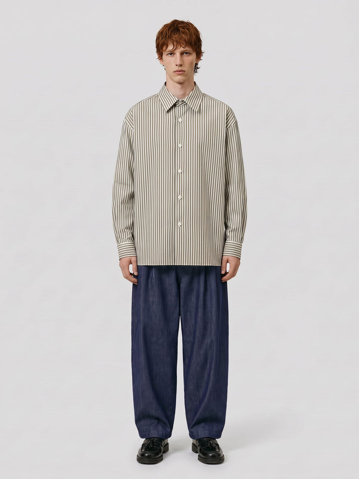 Homme portant une chemise oversize blanche à rayures kaki Lebrun Paris, en pied, sur fond gris