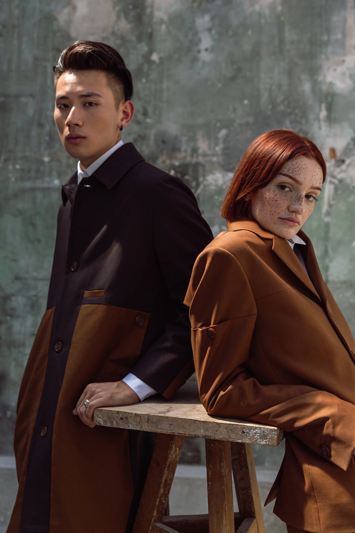 Un homme en manteau sombre à empiècement brun et une femme en manteau brun